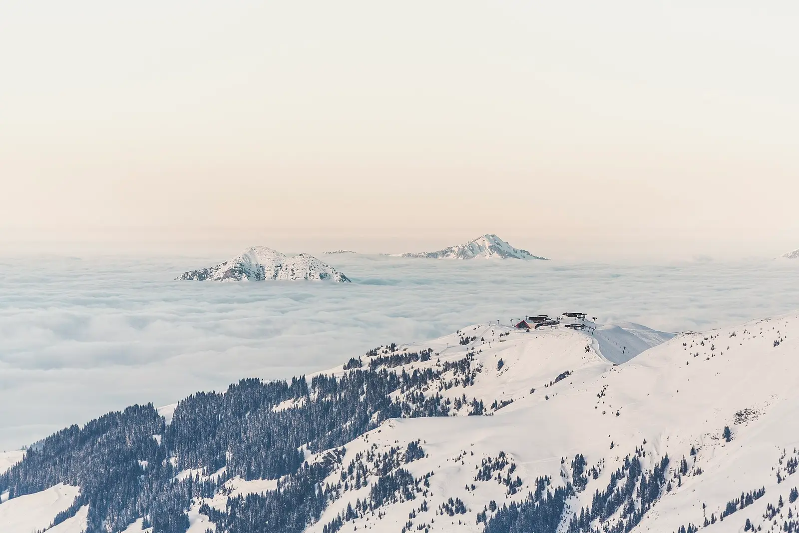 Snow-covered peaks of the Kitzbühel Alps rising above a sea of cloud